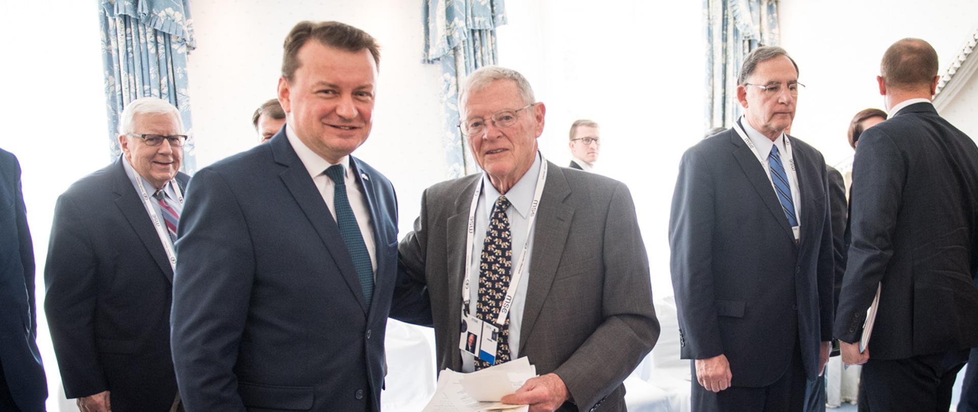 Zdjęcie przedstawiające Ministra Mariusza Błaszczaka podczas spotkania z innymi uczestnikami. 