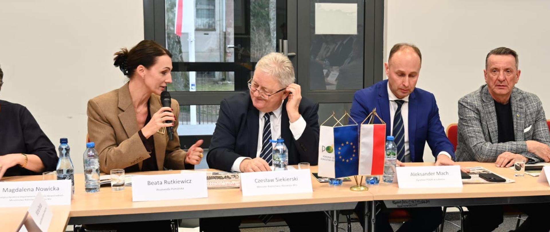 kilka osób siedzi przy stole, kobieta (wojewoda) przemawia