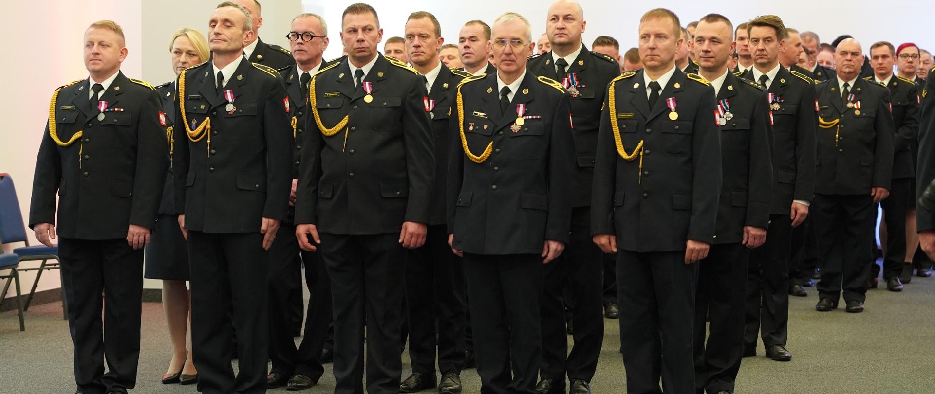 Strażacy stoją w kolumnie. 