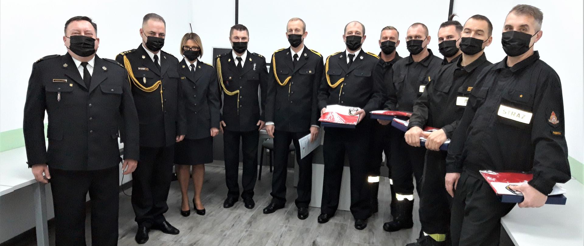 ustawienie w szeregu strażacy w mundurach wyjściowych wraz z kadrą kierowniczą