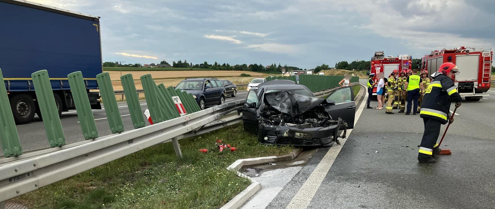 Na zdjęciu znajdują się strażacy, wraz pojazdu oraz samochody strażackie ustawione na autostradzie