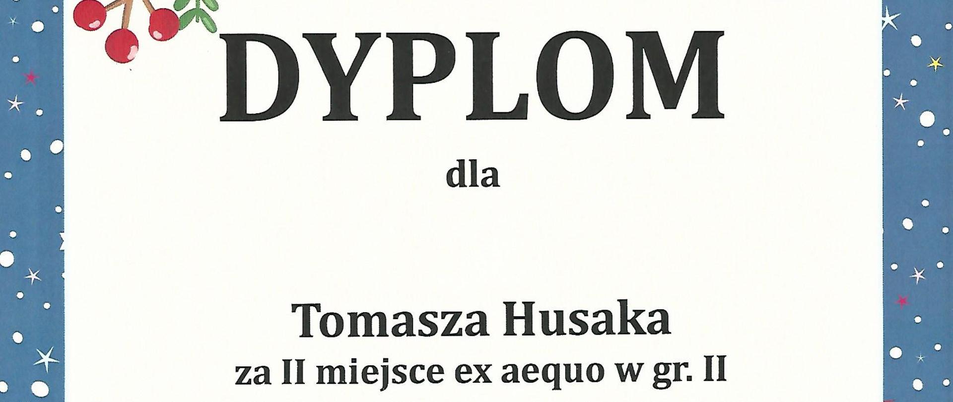 Grafika - dyplom. Tło białe, jedynie obramowanie w kolorze ciemnoniebieskim - z elementami graficznymi przedstawiającymi zimę (gwiazdki, płatki śniegu) oraz okres świąteczny - ubrane choinki i sanie świętego Mikołaja z zaprzęgiem reniferów. Na górze napis Agencja Artystyczna MODRAN, Państwowa Szkoła Muzyczna I i II stopnia im. K. i A. Szafranków w Rybniku. Poniżej duży napis DYPLOM, a jeszcze niżej kolejne napisy - dla Tomasz Husaka za zajęcie II miejsca ex aequo e grupie II w XVI Mikołajkowym Konkursie Gitarowym dla dzieci. Na samym dole imiona i nazwiska Jurorów wraz z ich podpisami. oraz miejscowość i data - Rybnik, 10 grudnia 2022 roku.
