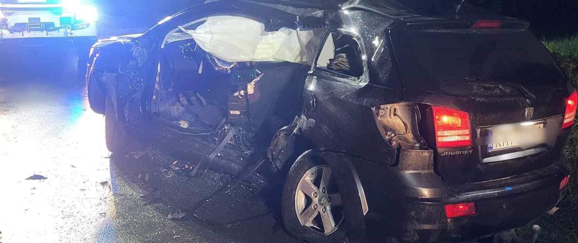 Na zdjęciu rozbity samochód osobowy z usuniętą lewą częścią karoserii na jezdni