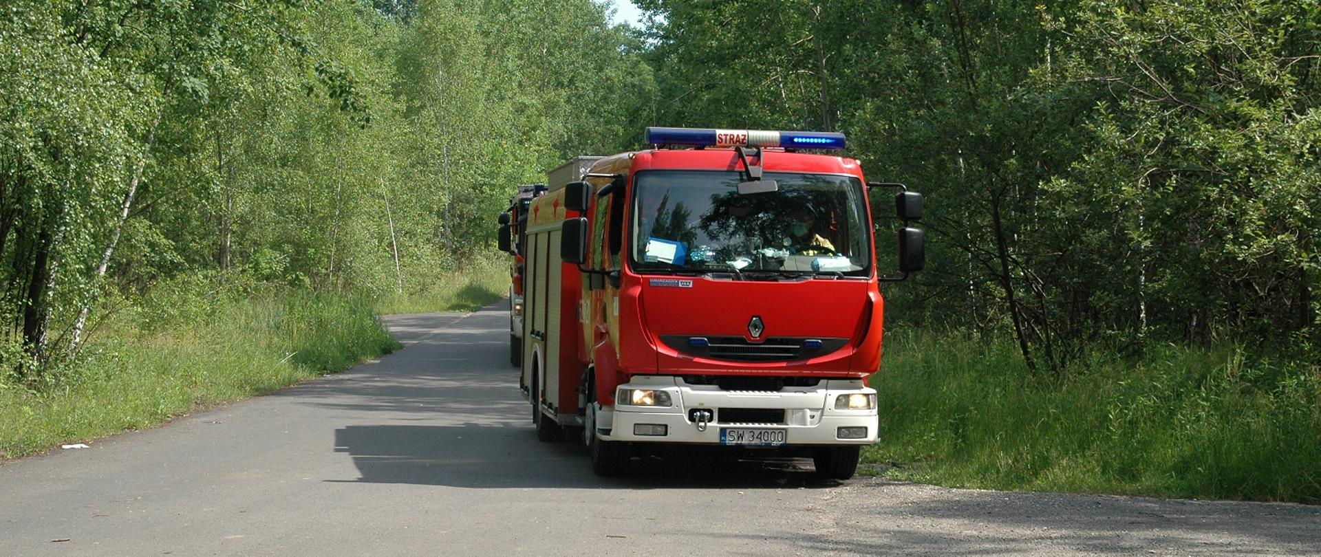 Zdjęcie przedstawia samochody pożarniczej dojeżdżające do miejsca ćwiczeń.