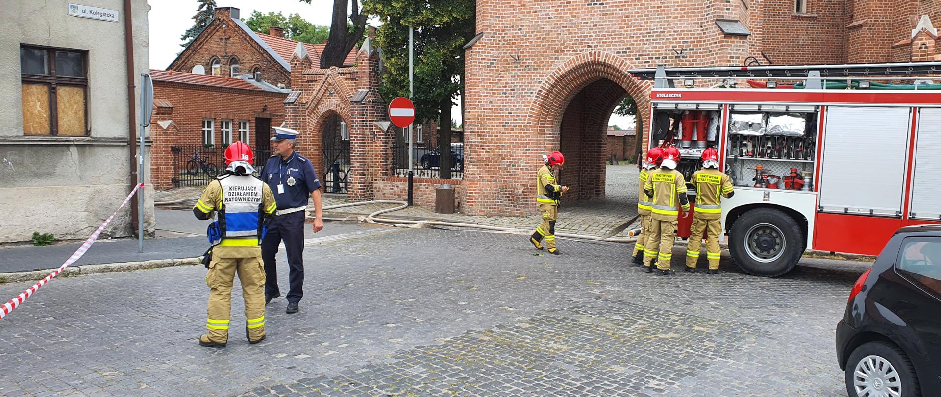Na zdjęciu strażacy oraz policjant zabezpieczają miejsce zdarzenia