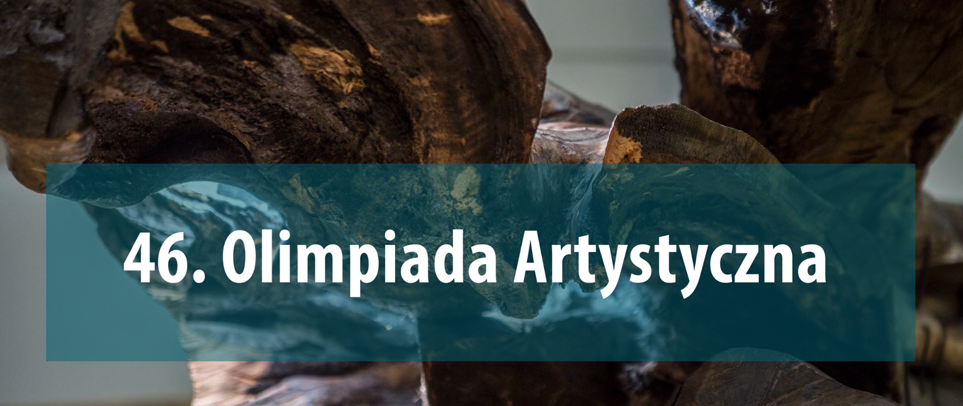 Biały napis 46. Olimpiada Artystyczna na transparentnym turkusowym prostokątnym tle. Na drugim planie organiczna forma rzeźbiarska.