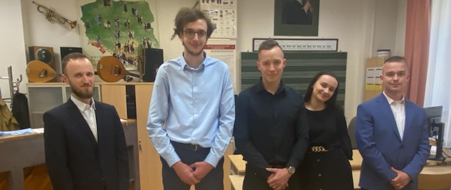 Dyplomanci PSM II st. z nauczycielem w sali lekcyjnej