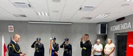 Komendant czytający ślubowanie oraz nowy strażak przysięgający rotę ślubowania.