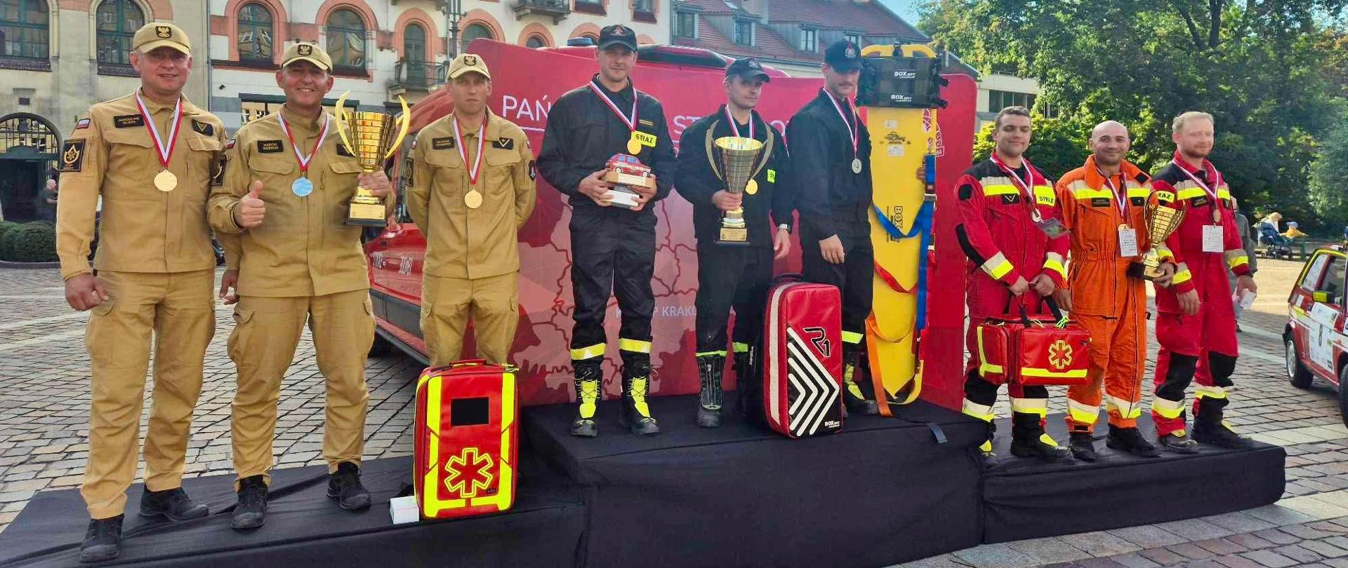 grupa strażaków na podium z pucharami