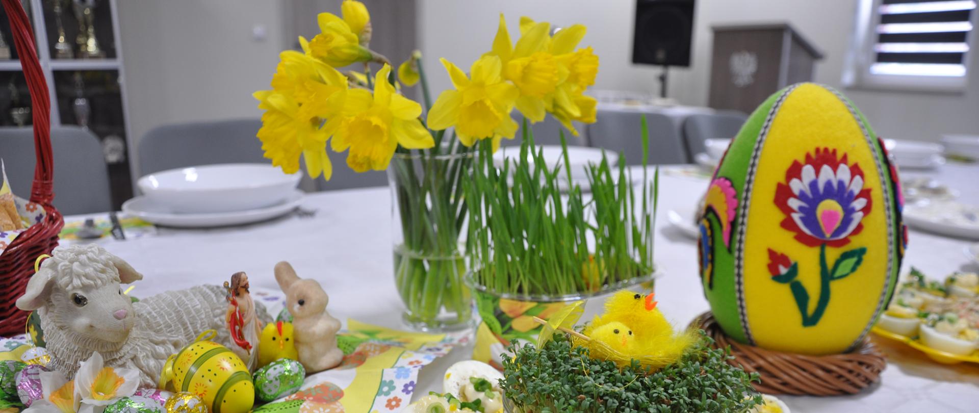 widok zastawionego stołu jajeczkami, zajączkami jedzeniem oraz zastawą i sztućcami