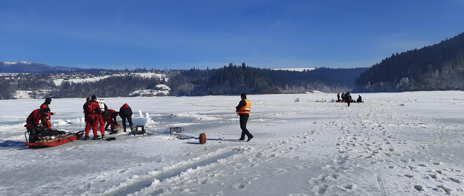 Strażacy ćwiczący na pokrywie lodowej. Zamarznięte jezioro Czorsztyńskie. Nurkowanie podlodowe.