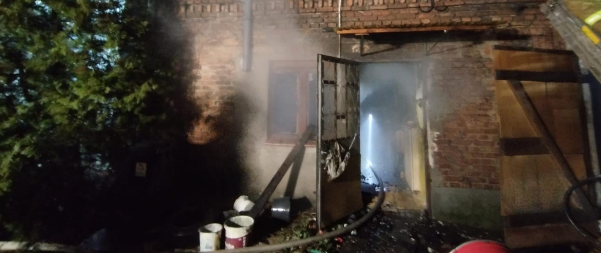 Na zdjęciu widać zadymienie w budynku, który się pali