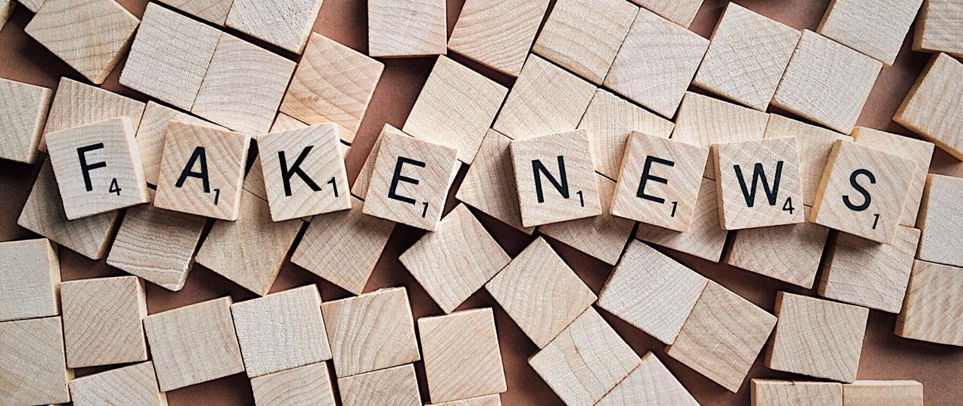 Drewniane klocki do gry w scrabble układające się w napis "fake news".