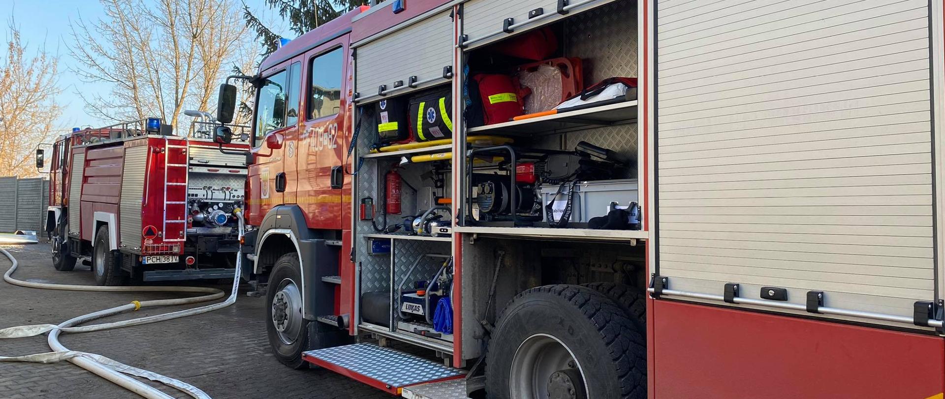 pojzdy pozarnicze oraz rozwinięte węże na miejscu pożaru