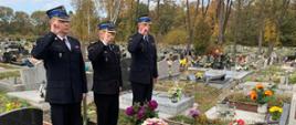 Komendant Miejski Państwowej Straży Pożarnej w Zabrzu st. bryg. Tomasz Bajerczak wraz z Zastępcą Komendanta Miejskiego Państwowej Straży Pożarnej w Zabrzu bryg. Wojciechem Delą i kierownikiem sekcji kwatermistrzowsko-technicznej st. kpt. Piotrem Halembą oddają honor przed grobem zmarłego strażaka.