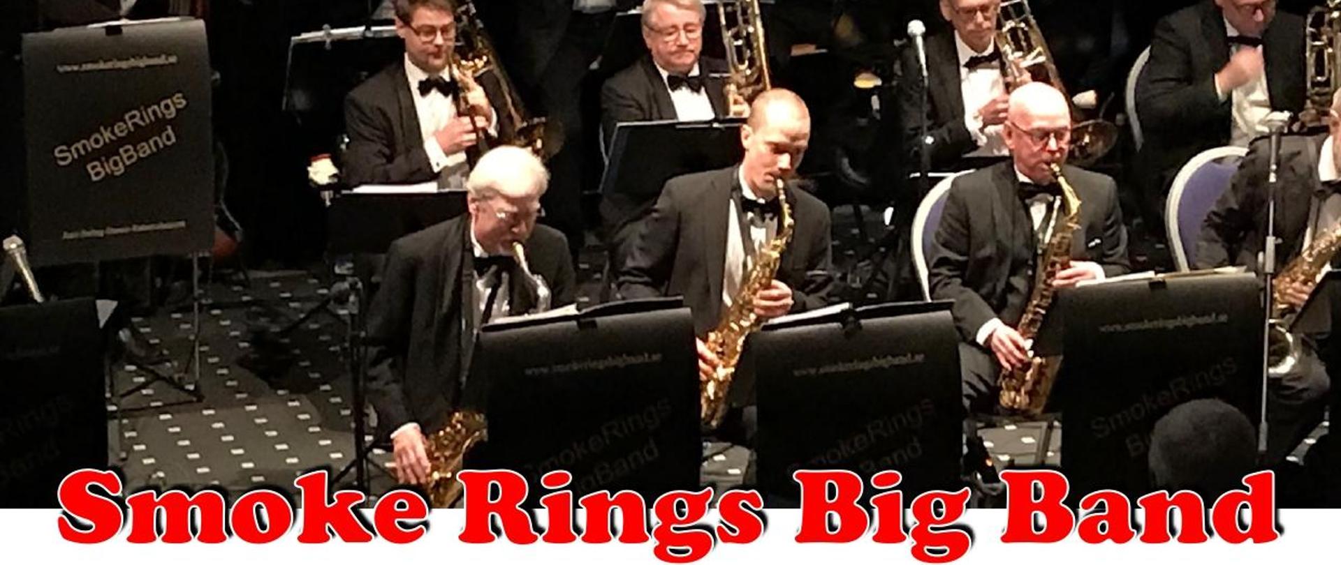 W górnej części obrazka grupa odświętnie ubranych mężczyzn, którzy grają na instrumentach muzycznych. Poniżej czerwony napis: "Smoke Rings Big Band". Dalej do dołu na białym tle niebieski napis: "koncert, sala koncertowa szkoły muzycznej w Kościerzynie, ul. Dworcowa 12", dalej czarnymi literami: "czwartek, 16 maja godz. 17:00" i czerwony "wstęp wolny".