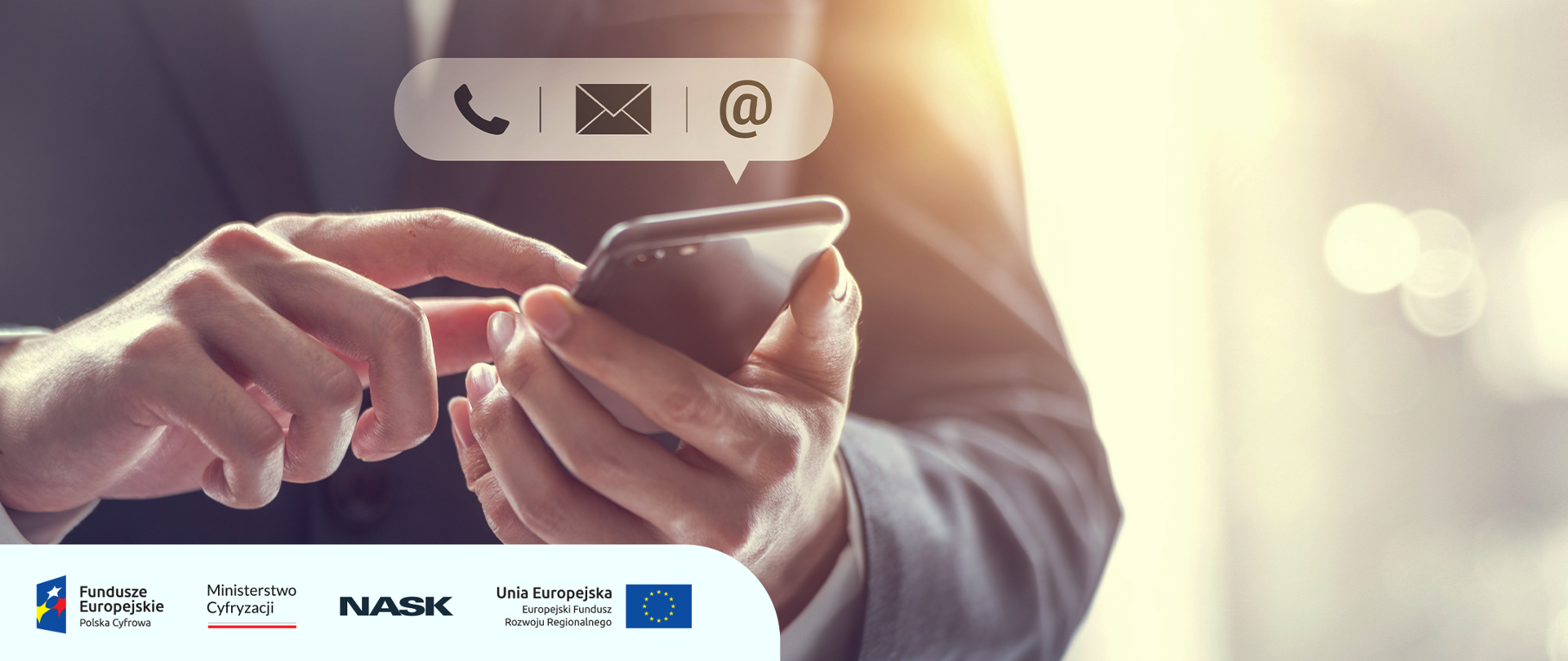 Na grafice widzimy dłonie mężczyzny trzymający w rękach telefon komórkowy. Nad telefonem widnieją ikony telefonu, wiadomości SMS oraz email. 
