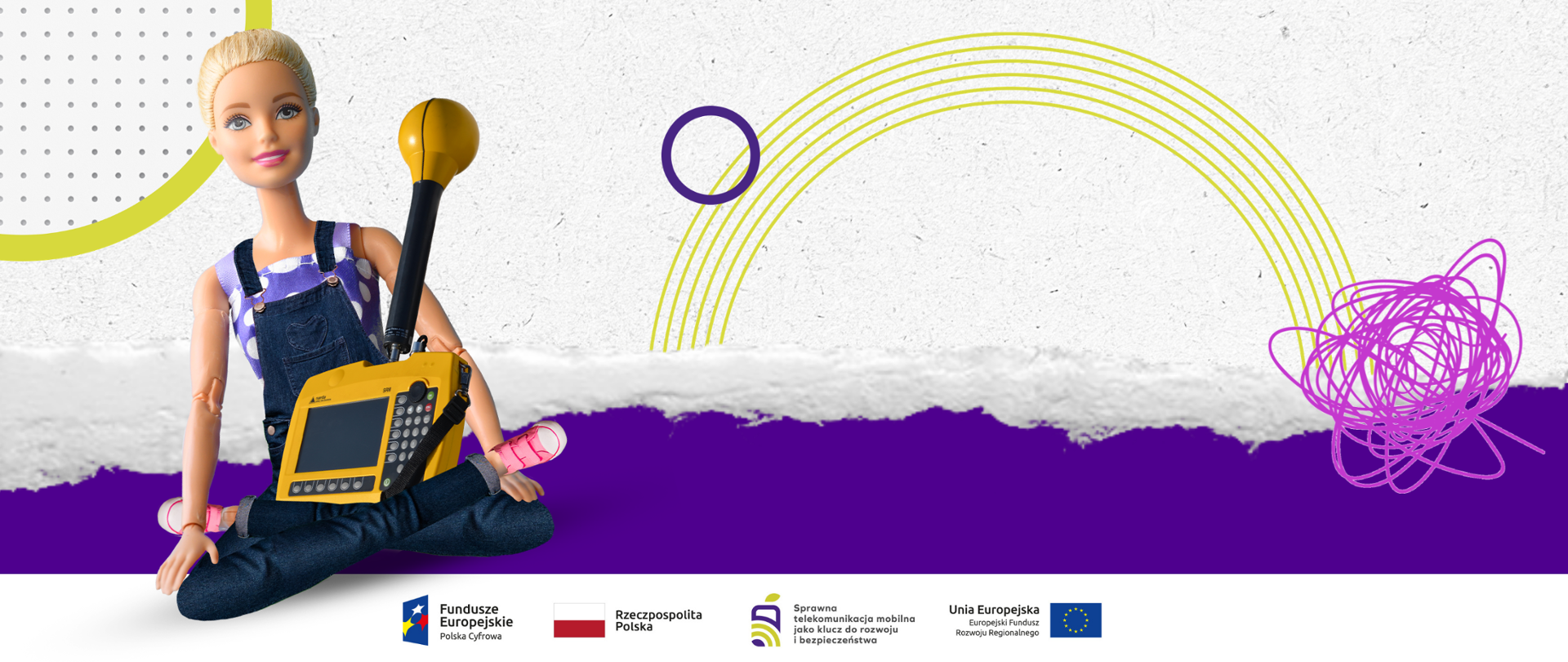 Lalka Barbie siedząca po turecku, trzymająca miernik Narda