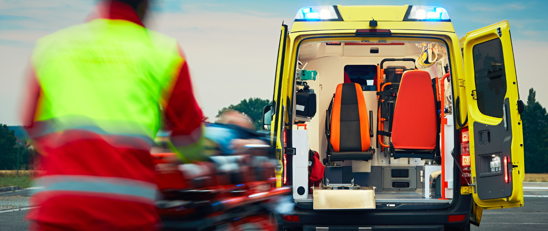 Na zdjęciu widoczna jest karetka pogotowia oraz ratownik medyczny 