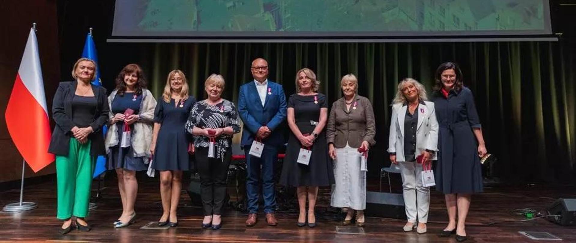 Grupa osób stoi na scenie, za nimi napis dzień samorządowca