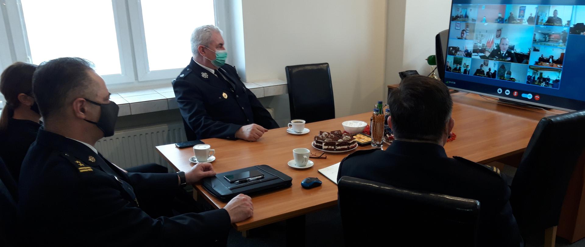 Komendant Powiatowy PSP, Prezes Zarządu Powiatowego OSP i Starosta Powiatowy siedzący przy stole przed ekranem