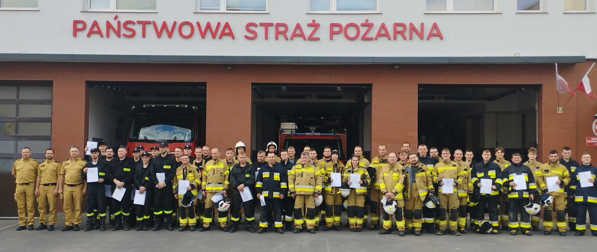 Przed budynkiem komendy znajdują funkcjonariusze i druhowie OSP, którzy uczestniczyli w szkoleniu podstawowym strażaka ratownika OSP. 