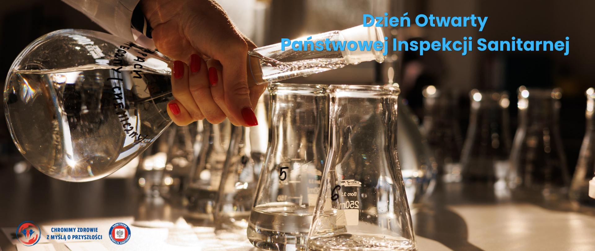 Kolby laboratoryjne z odczynnikami. Po prawej stronie napis: Dzień Otwarty Państwowej Inspekcji Sanitarnej. W lewym dolnym rogu logo Państwowej Inspekcji Sanitarnej: "Chronimy zdrowie z myślą o przyszłości".