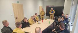 Fotografia przedstawia szkolenie strażaków OSP, która odbywa się w zamkniętej sali konferencyjnej.