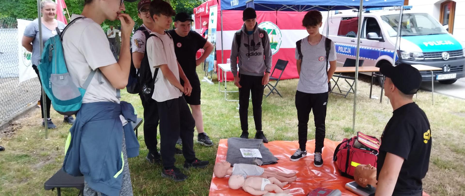 Na zdjęciu widnieją osoby słuchające funkcjonariusza