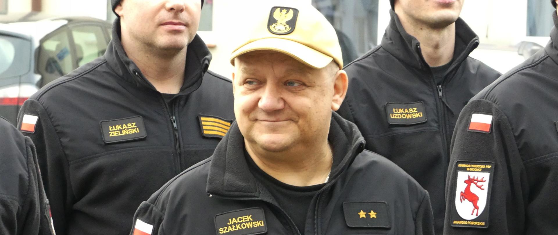 Zdjęcie przedstawia przechodzącego na zaopatrzenie emerytalne st. asp. Jacka Szałkowskiego podczas uroczystej zmiany służby połączonej z podziękowaniem za służbę.