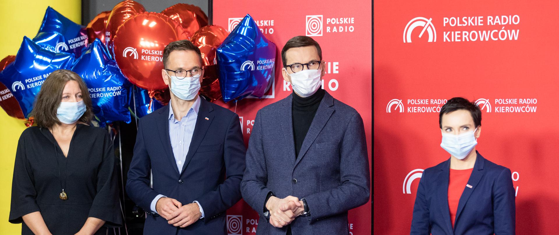 Grupa osób stoi na tle ścianki Polskiego Radia wśród nich Premier Morawiecki, minister Buda, poseł Lichocka i prezes Kamiński 