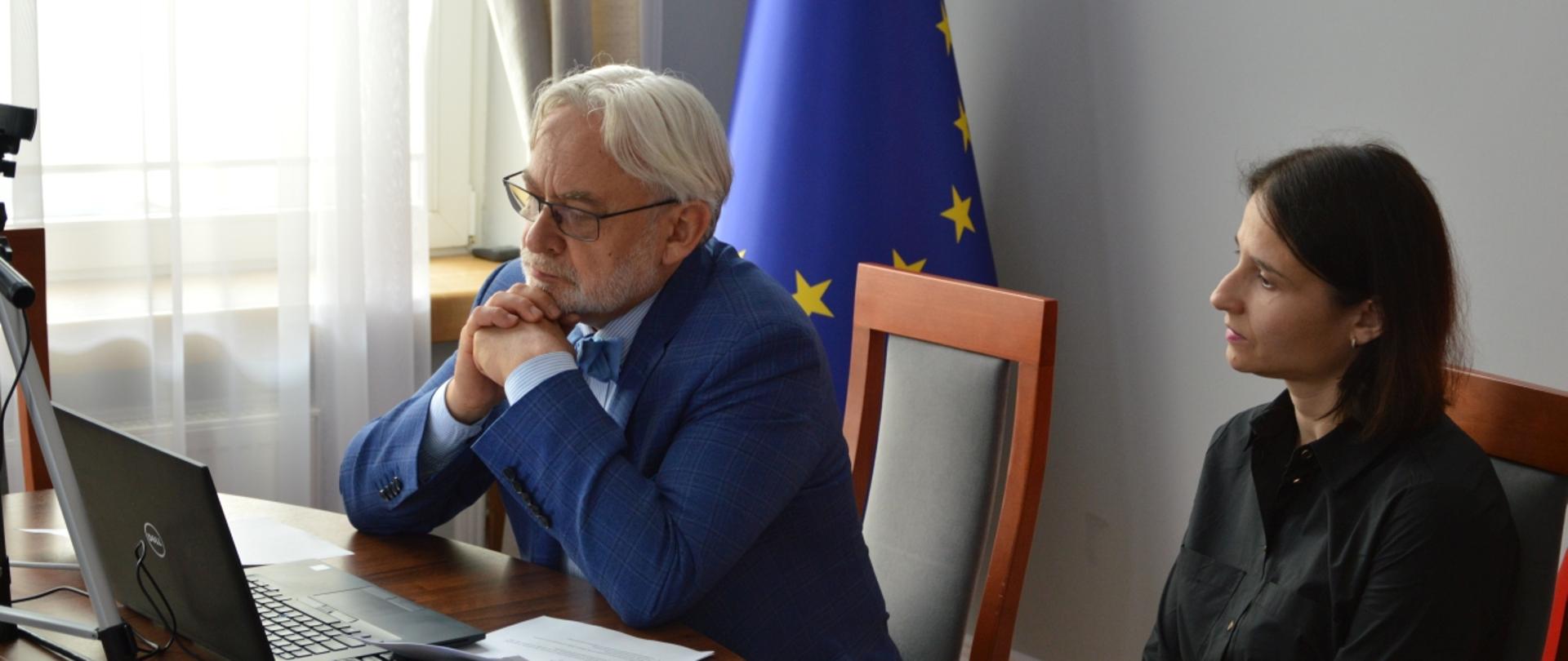 Prof. Maksymowicz patrzy w monitor, za nim siedzi dyrektor Małgorzata Zadrożna