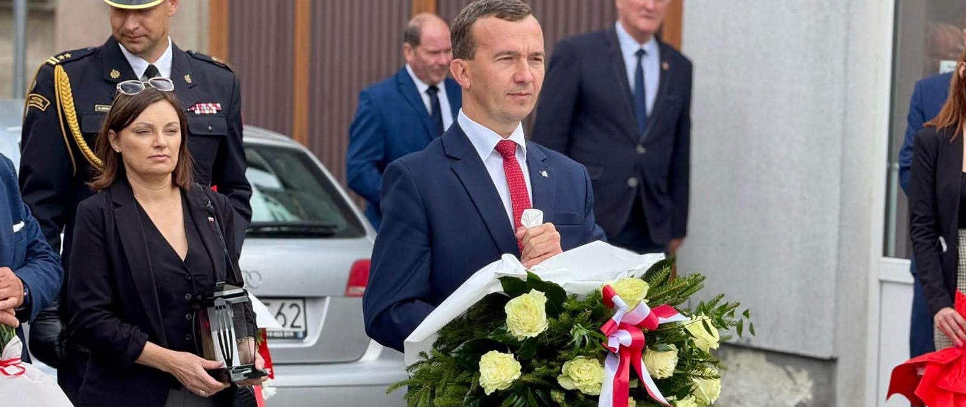 Mężczyzna idzie z wieńcem 