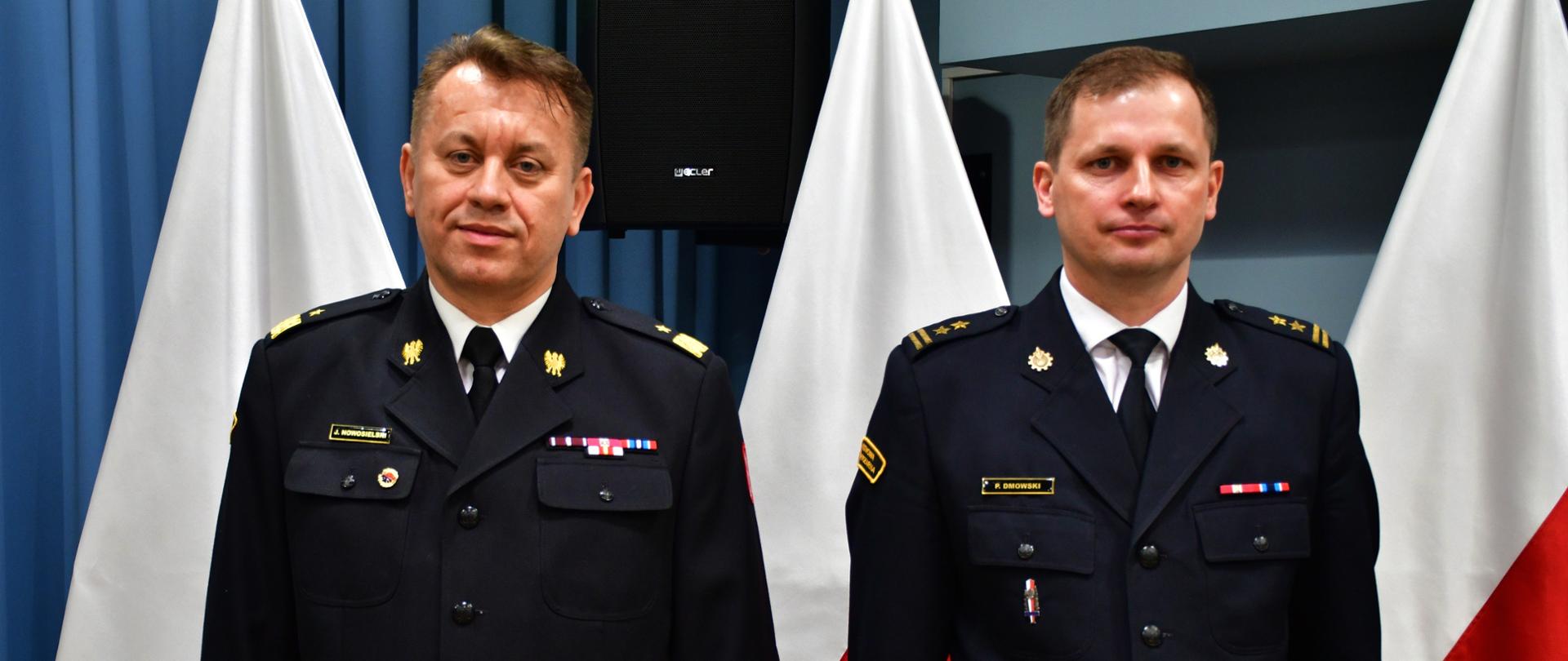 Powołanie Komendanta Powiatowego PSP w Sokołowie Podlaskim bryg. Pawła Dmowskiego - na zdjęciu Komendant Wojewódzki i Komendant Powiatowy stoją na baczność, za nimi ustawione flagi Polski
