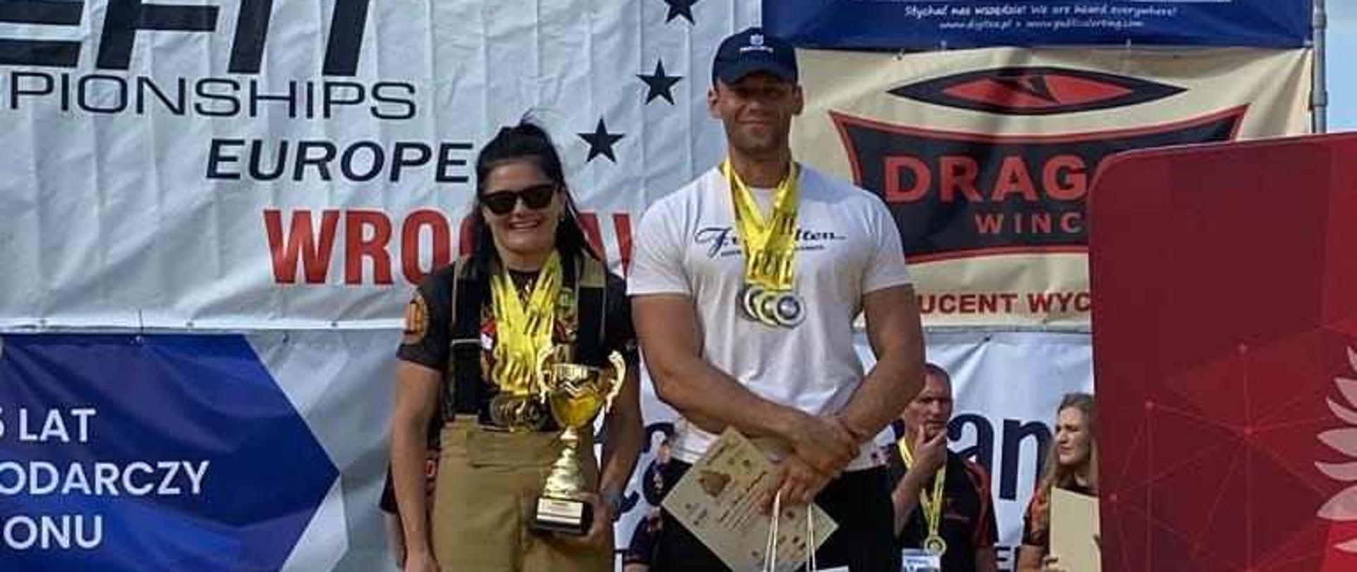 Strażak z koleżanką na podium.