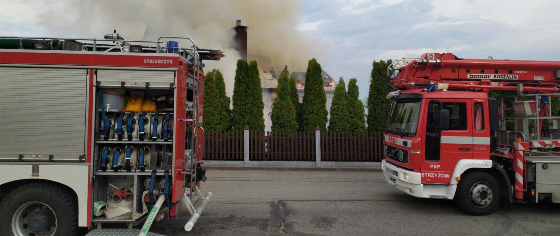Na zdjęciu widoczny pożar budynku mieszkalnego oraz dwa zastępy straży pożarnej.