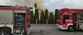 Na zdjęciu widoczny pożar budynku mieszkalnego oraz dwa zastępy straży pożarnej.