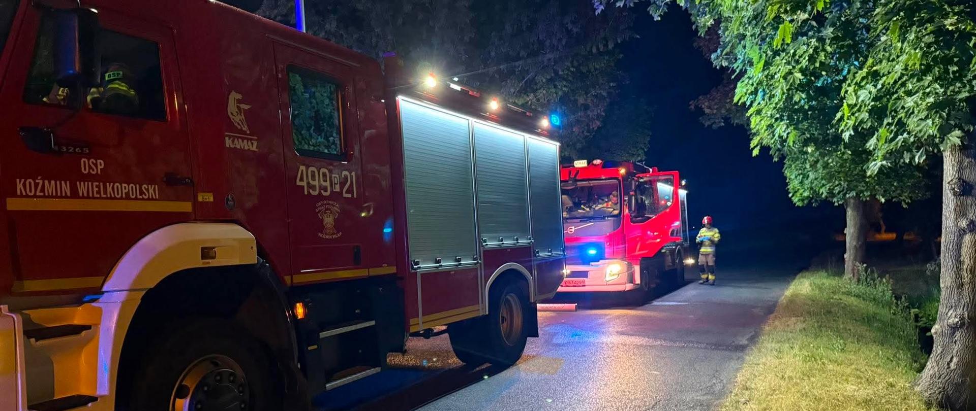Zdjęcie przedstawiają pojazdy straży pożarnej, które stoja na drodze w miejscu zdarzenia drogowego.