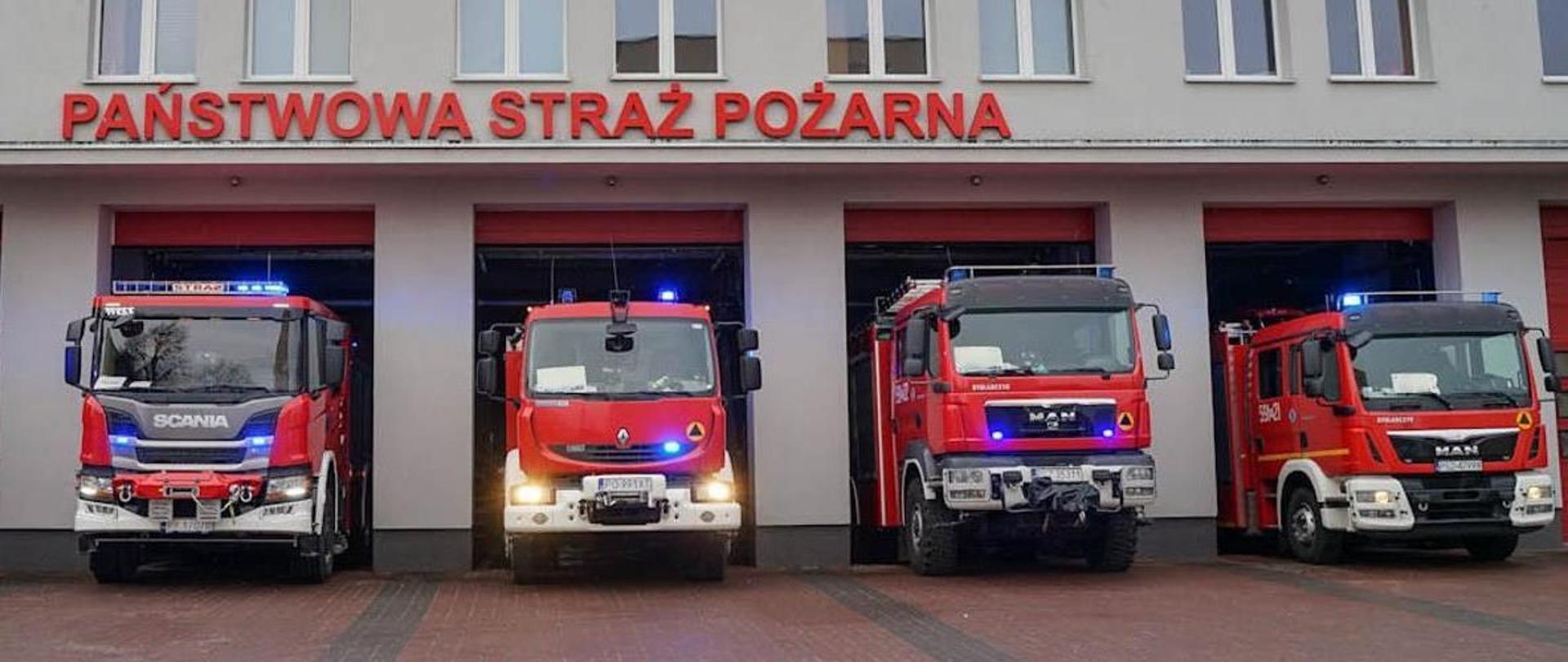 Samochody strażackie na tle budynku komendy PSP