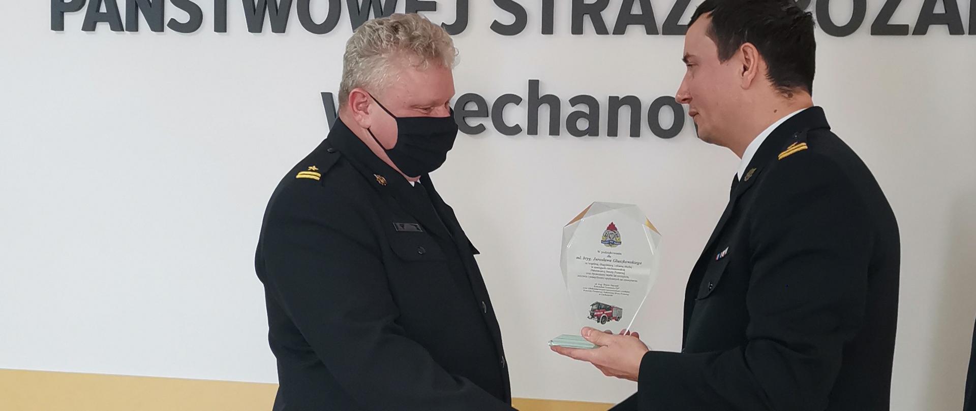 Na zdjęciu mł. bryg. Tomasz Gajewski- Komendant Powiatowy Państwowej Straży Pożarnej w Ciechanowie wręczający statuetkę mł. bryg. Jarosławowi Głuszkowskiemu