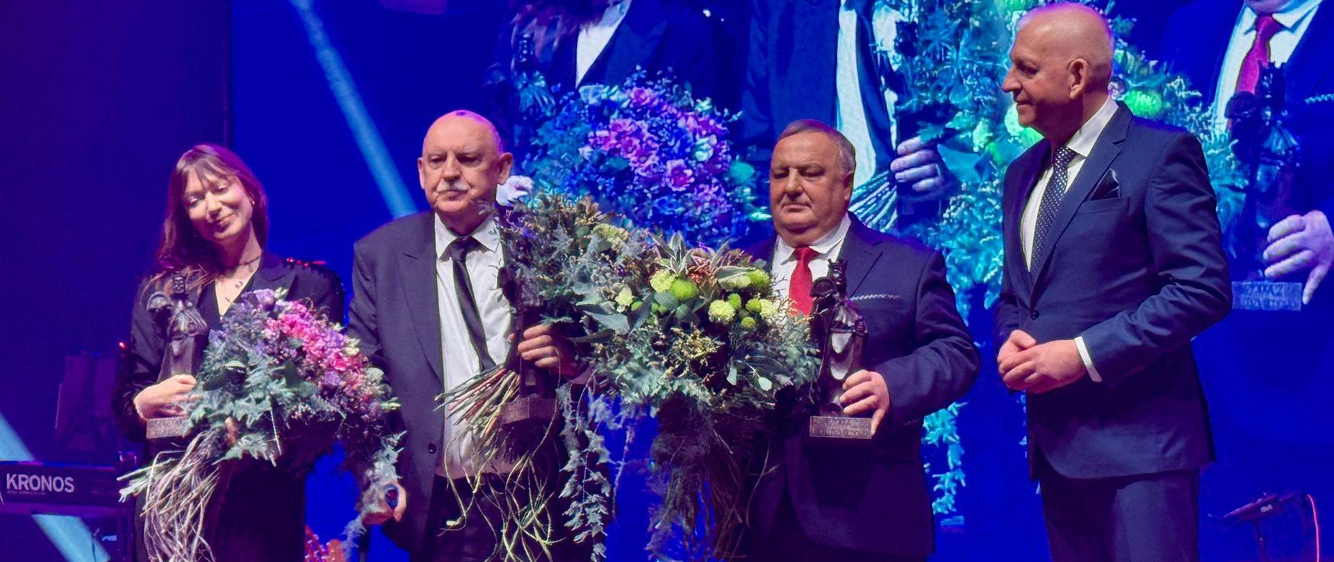 Na scenie nagrodzenie z kwiatami i ze statuetkami