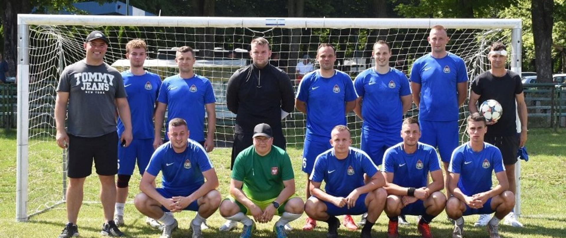 Na zdjęciu zawodnicy drużyny strażaków na tle bramki piłkarskiej.