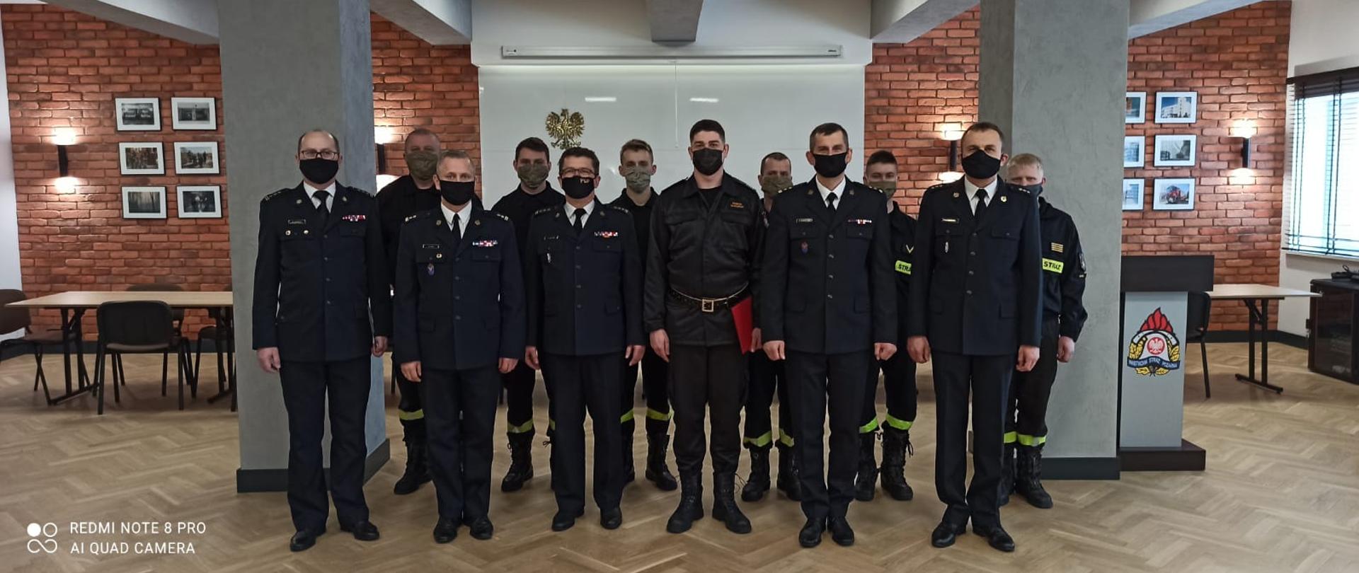 Na zdjęciu znajdują się: Podlaski Komendant Wojewódzki PSP, Z-ca Podlaskiego Komendanta Wojewódzkiego PSP, Naczelnik wydziału kadr KW PSP w Białymstoku, Komendant Powiatowy PSP w Mońkach, Dowódca JRG w Mońkach wraz ze zmianą służbową