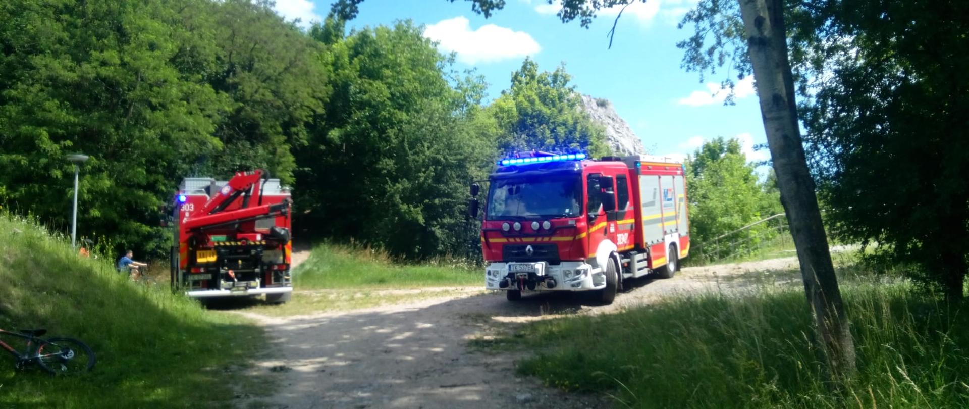 Zdjęcie przedstawia miejsce zdarzenia: widać dwa samochody pożarnicze a w głębi Skała Geologów w kamieniołomie Kadzielnia.
