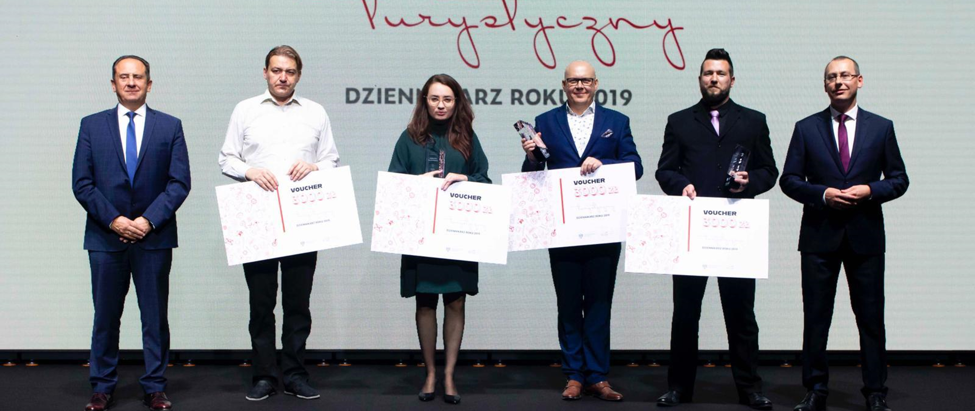 Na zdjęciu na pierwszym planie stoją laureaci oraz min. Andrzej Gut-Mostowy 