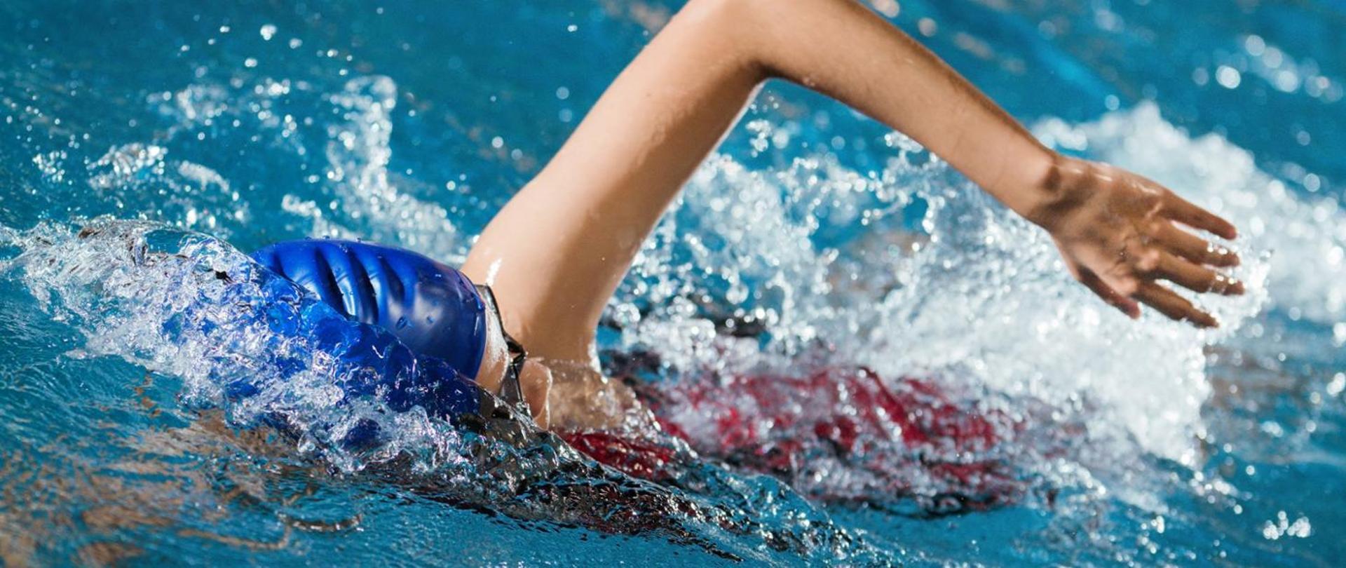 basen, w nim pływak w czepku