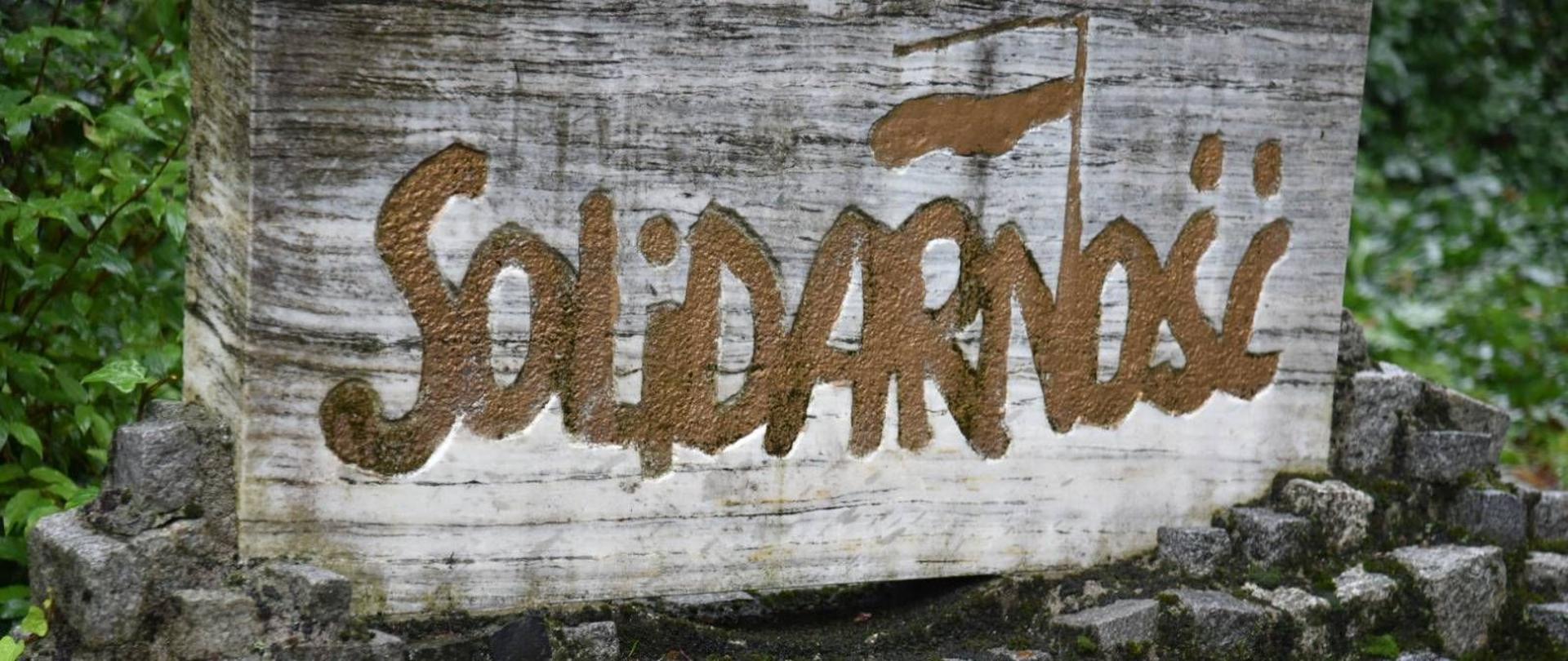 Na kamiennej płycie wyryty napis Solidarność 