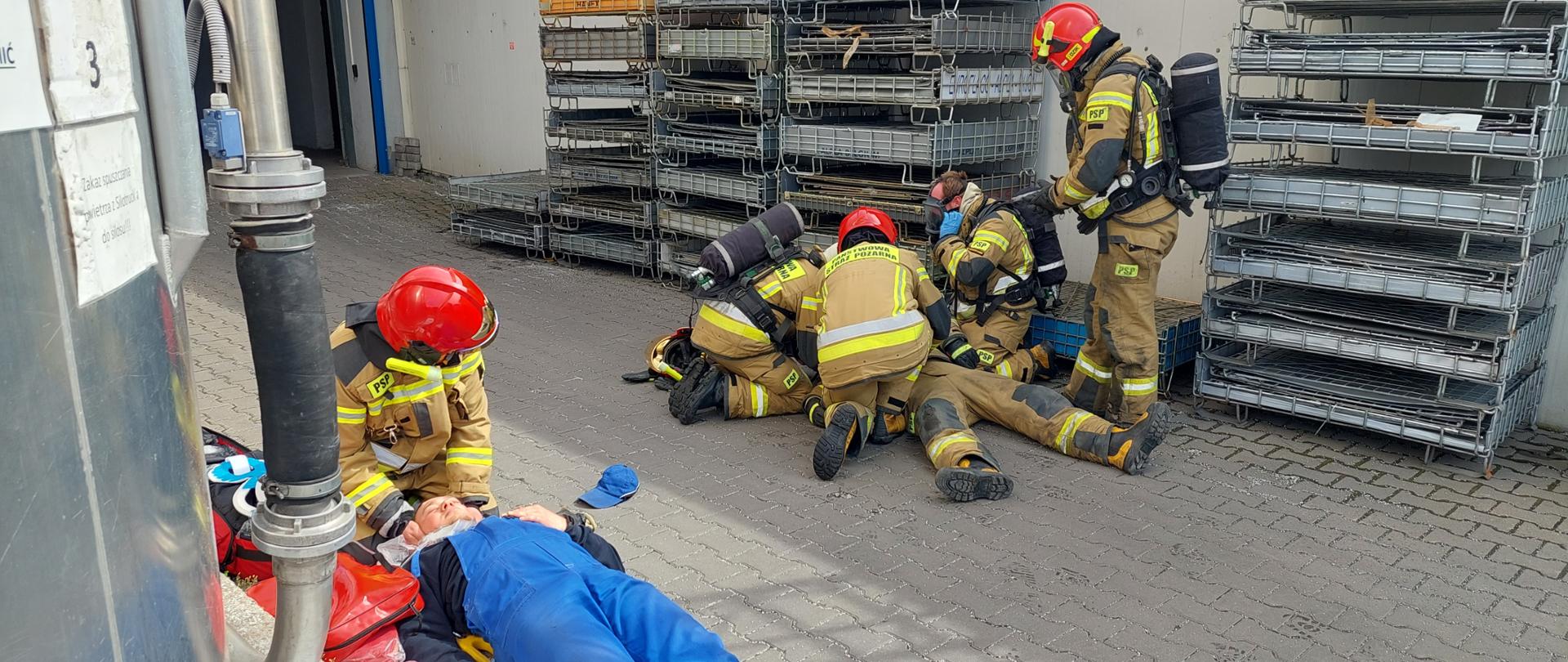 strażacy podczas ćwiczeń udzielający pomocy poszkodowanym