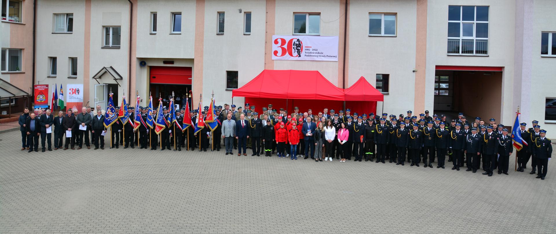 Na zdjęciu widoczni strażacy, poczty sztandarowe, przedstawiciele sejmu i senatu, służb mundurowych, władz samorządowych podczas uroczystości związanych z obchodami powiatowego Dnia Strażaka.