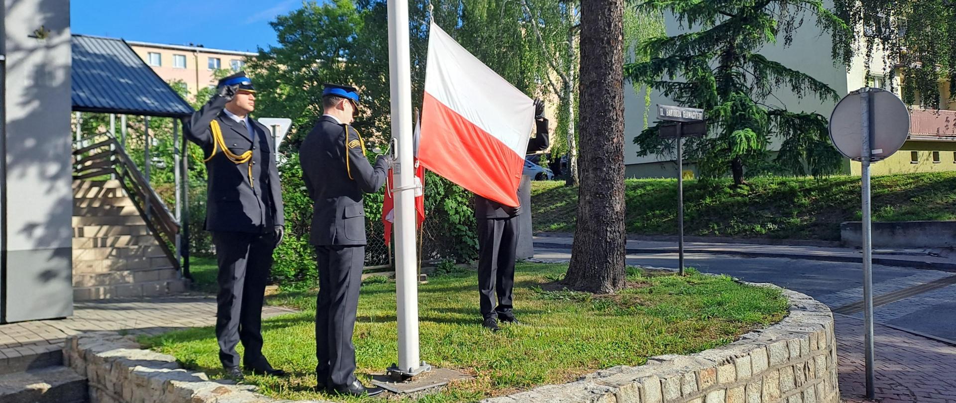 strażacy wciągają flagę na maszt